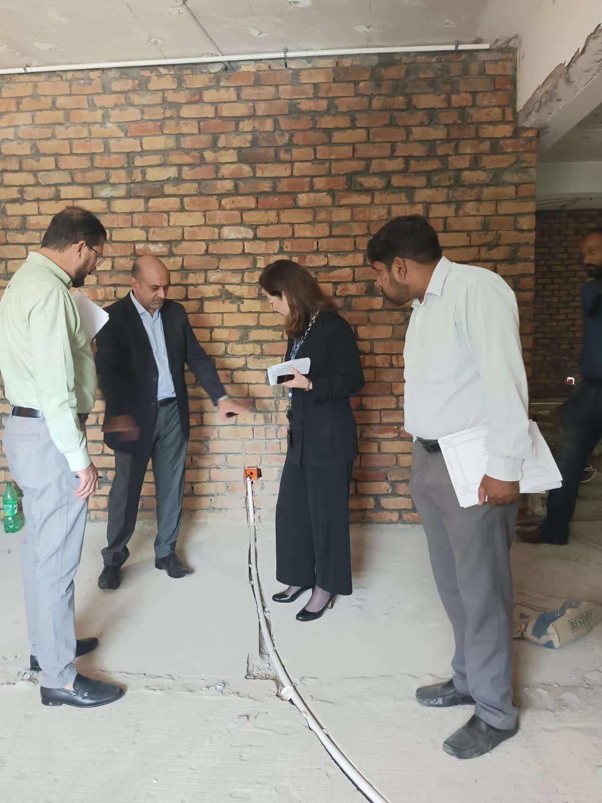 Ali Brothers and IOM representatives inspecting exposed wall and service work